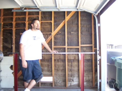 1991 Ford Bronco - A man stands in a garage, leaning on a welding table with exposed wall insulation behind him.