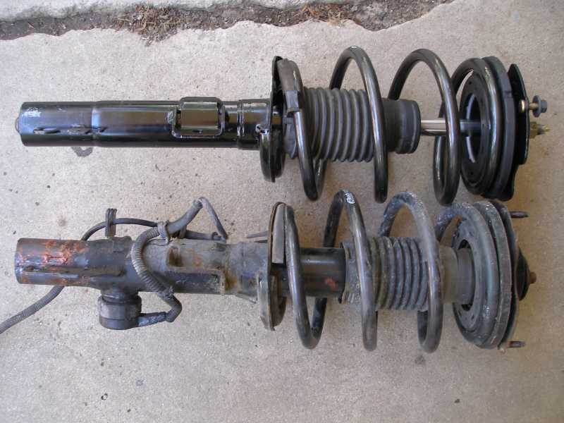 Two car struts with coil springs, one new and one rusted