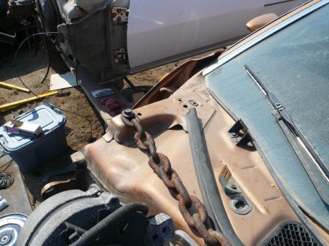 1975 Ford Ranchero - A close-up view of a vehicle's engine bay, showing a heavy chain and part of the open door.