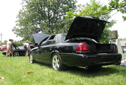 2003 Mercury Marauder - A black sedan is displayed with its hood and trunk open at an outdoor event.