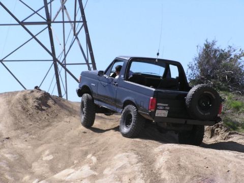 1990 Ford Bronco - This 1990 Ford Bronco is captured mid-climb on a dusty trail, its off-road capabilities.
