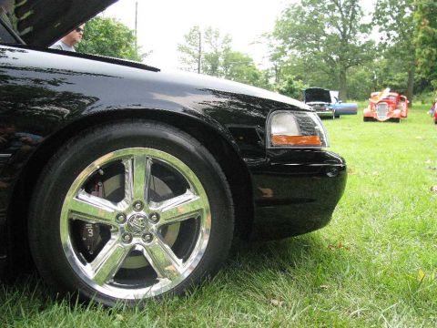 2003 Mercury Marauder - A black 2003 Mercury Marauder is parked on grass with its hood open, other vehicles in the background.