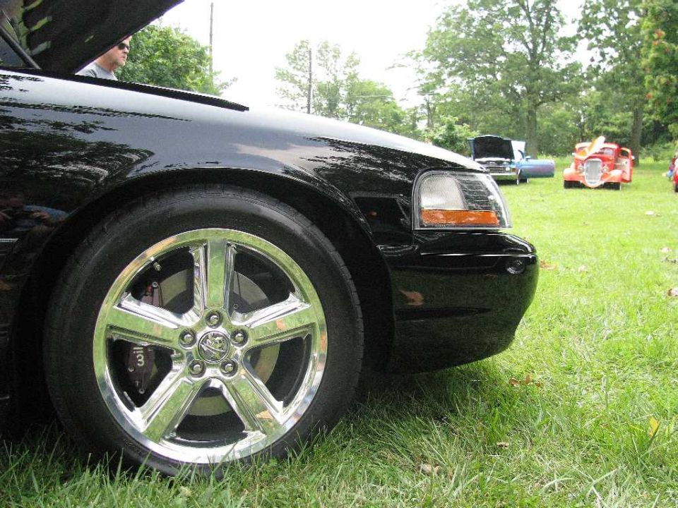 Black 2003 Mercury Marauder front quarter panel with chrome five-spoke wheel and visible brake caliper
