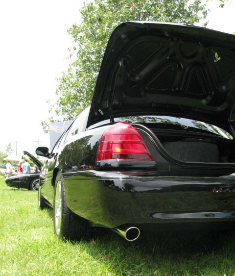 2003 Mercury Marauder - The rear of a black sedan is shown with its trunk open, parked on a grassy area with another vehicle visible in the background.