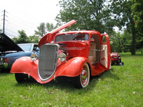 2003 Mercury Marauder - A classic red hot rod coupe is displayed with its hood and door open at an outdoor event.