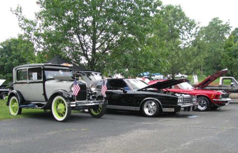 2003 Mercury Marauder - A collection of vintage automobiles are displayed outdoors, with some hoods open for viewing.