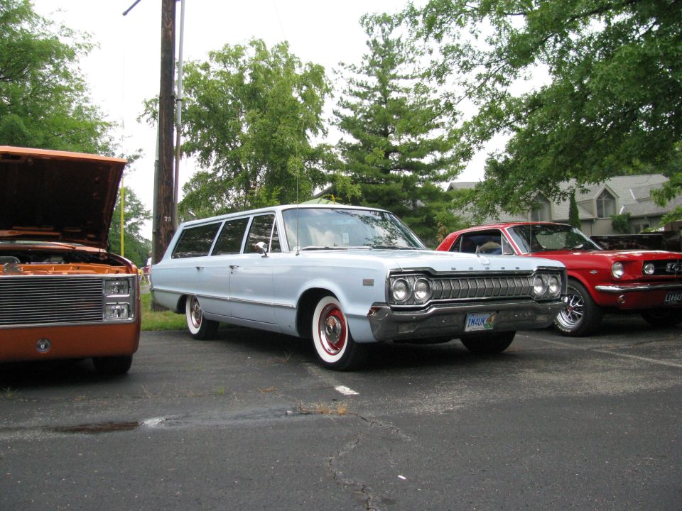 Light blue station wagon and red coupe parked, orange pickup truck hood open.