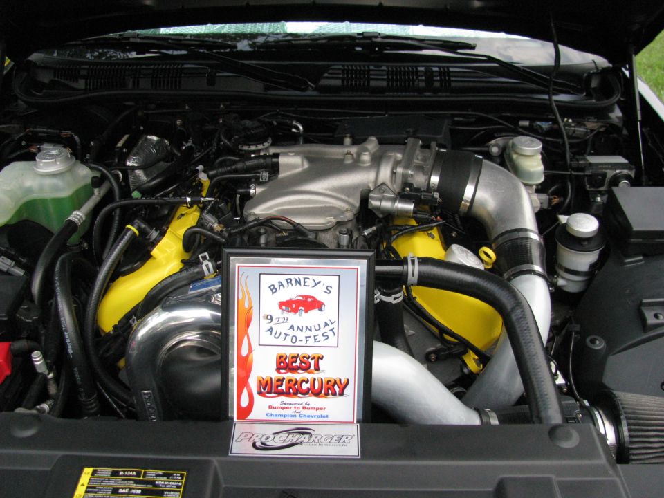 Modified engine bay with ProCharger supercharger and yellow intake manifolds.