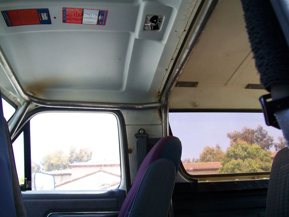 Interior view of a 1990 Ford Bronco showing a roll cage, seats, and windows