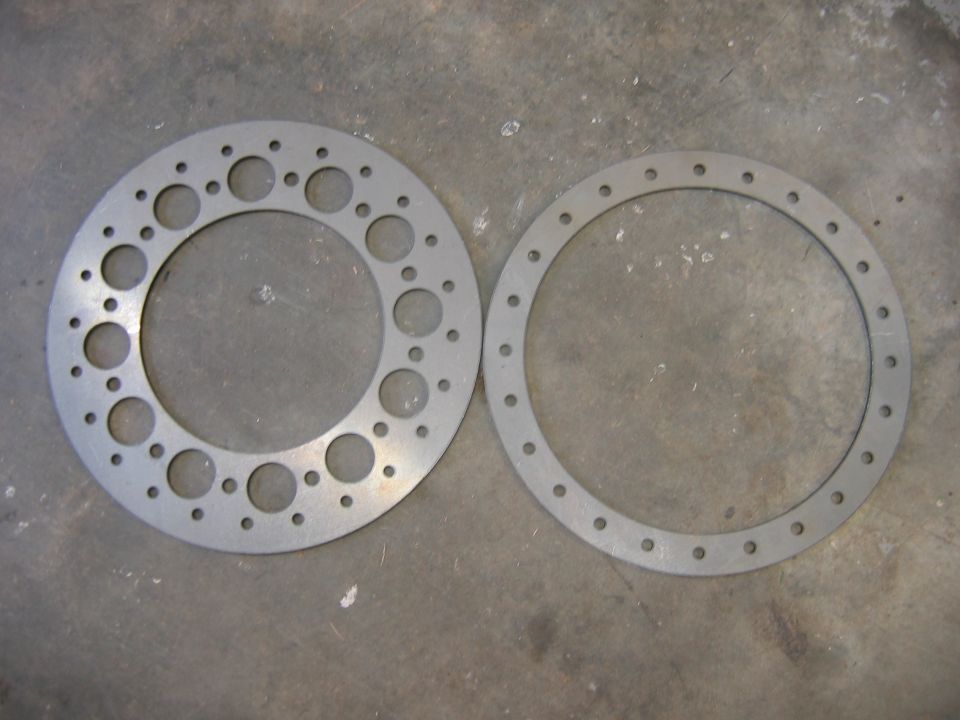 Two metal rings with various holes, one with a larger inner diameter and more holes