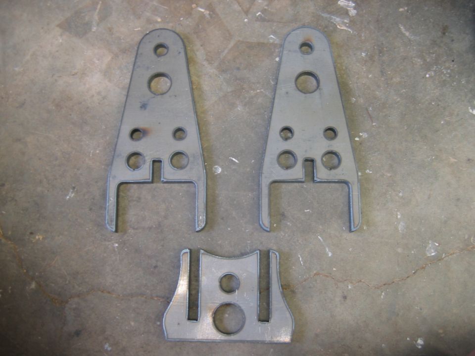 Three metal brackets on a concrete floor