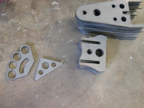 1992 Ford Mustang - Several different types of metal brackets are piled on a workshop floor.