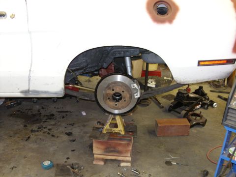 1978 Ford Mustang II - Rear brake assembly of a car undergoing maintenance in a garage.