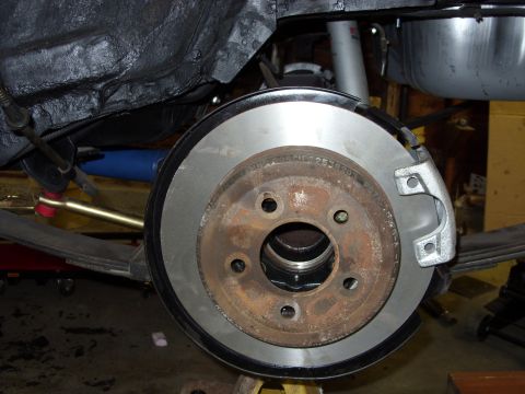 1978 Ford Mustang II - The rear brake assembly of a vehicle is shown, a rusty rotor and a new caliper.