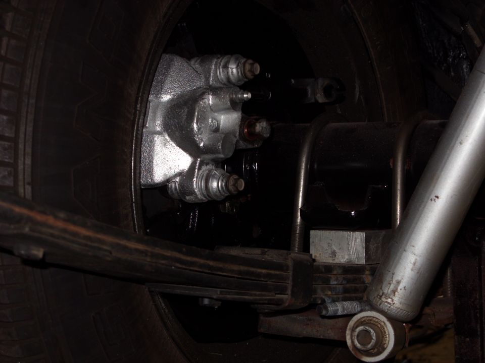Rear brake caliper and leaf spring assembly with shock absorber