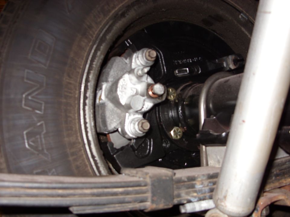Rear drum brake assembly with caliper and leaf springs