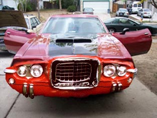 1971 Ford Ranchero - A red coupe with its hood and doors open sits in a driveway, with other vehicles visible in the background.