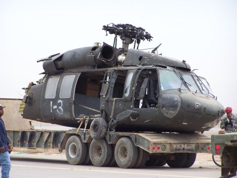 1995 Ford Bronco - A damaged black helicopter, marked with '1-3', is loaded onto a large trailer for transport.