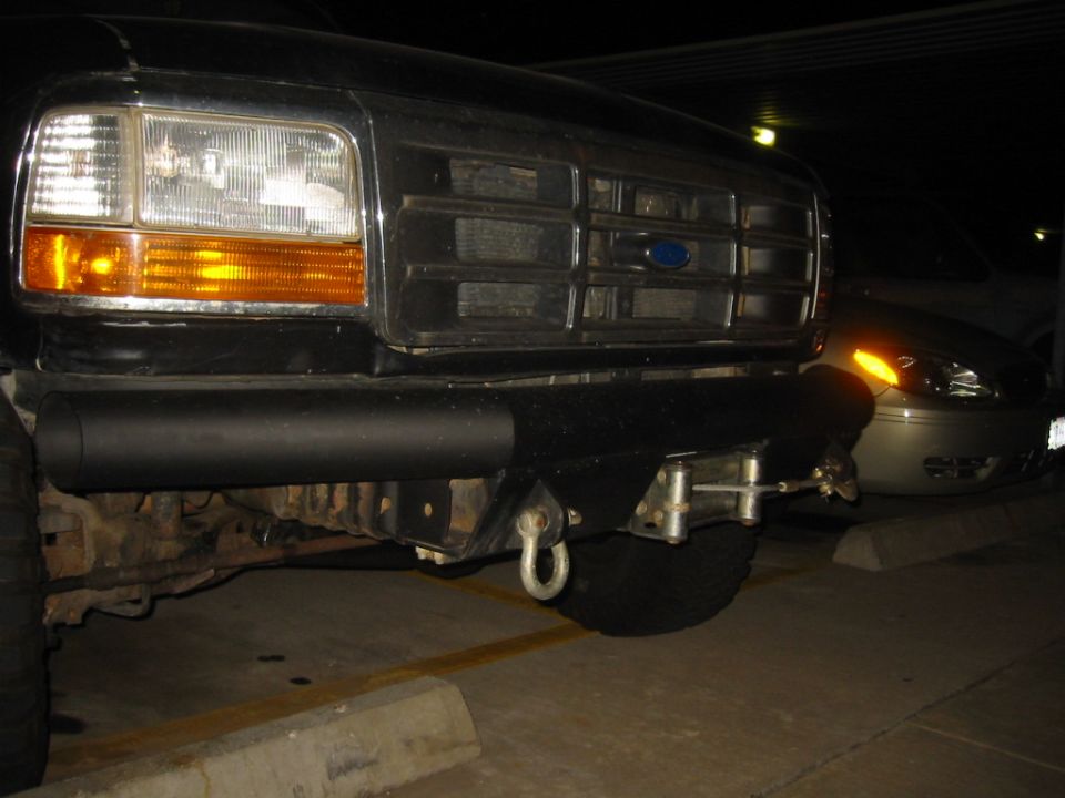 Custom tube front bumper with D-ring shackle on a black Ford truck at night