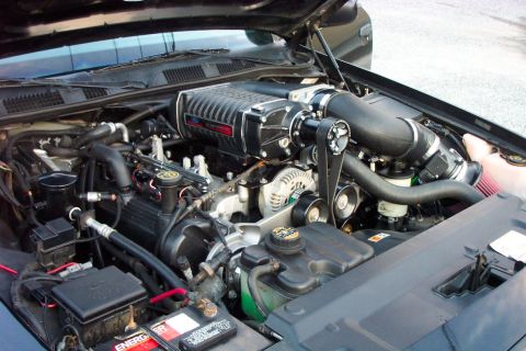 2003 Ford Crown Victoria - Close-up view of a modified engine bay, highlighting a prominent supercharger unit.