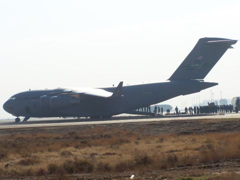 1995 Ford Bronco - A large US Air Force cargo plane is parked on a tarmac with a group of people standing around it.