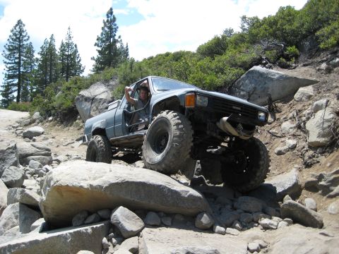 1999 Jeep Grand Cherokee - Off-road Toyota pickup truck tackling a challenging rocky terrain.
