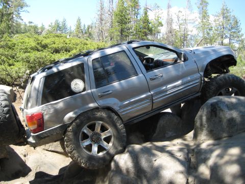 1999 Jeep Grand Cherokee - Silver 1999 Jeep Grand Cherokee navigates a rocky trail with its suspension articulated.
