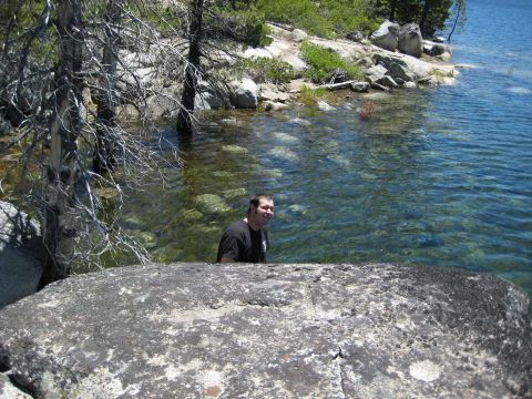 1999 Jeep Grand Cherokee - Man enjoys the clear water of a lake surrounded by rocks and trees.