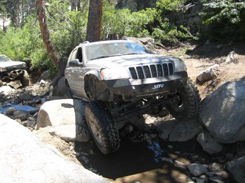 1999 Jeep Grand Cherokee - This Jeep Grand Cherokee is shown tackling a rocky trail, with another vehicle following behind.