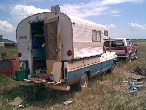 1969 Ford F-100 - A vintage Ford F-Series truck, likely from the late 1960s, is parked in a field with a camper shell and a Bronco behind it.