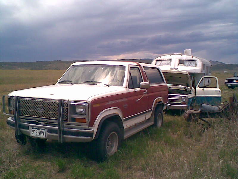 Red and white Ford Bronco with a grille guard and a license plate reading 938-DRY
