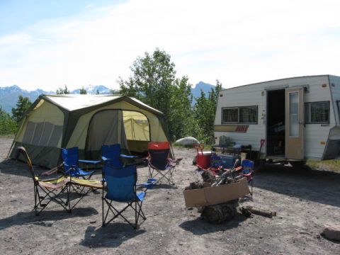 1978 Ford Bronco - A campsite is set up with a tent, trailer, chairs, and a fire pit, ready for outdoor recreation.