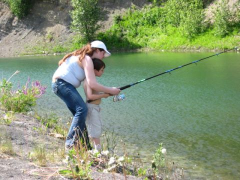 1978 Ford Bronco - Two people fishing by a lake on a sunny day.