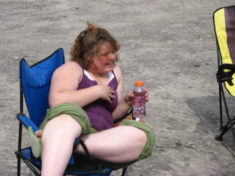 1978 Ford Bronco - A woman relaxes outdoors in a camping chair, holding a beverage bottle.