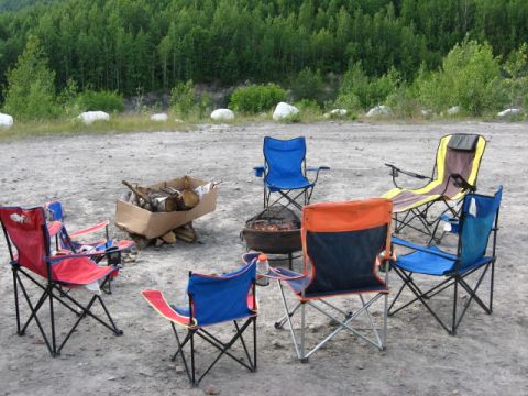 1978 Ford Bronco - A campsite scene with multiple folding chairs and a box of firewood set up for a gathering.