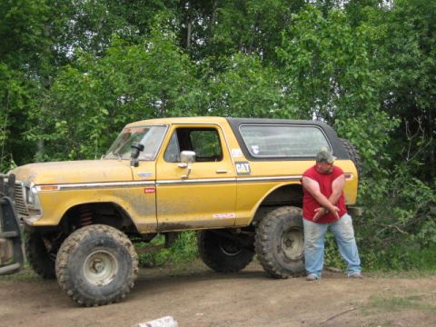 1978 Ford Bronco - A yellow 1978 Ford Bronco is parked outdoors with a man standing next to it.