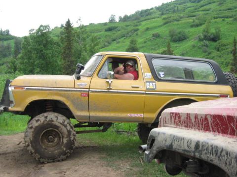 1978 Ford Bronco - A yellow 1978 Ford Bronco is shown off-road, with another vehicle partially visible in the foreground.