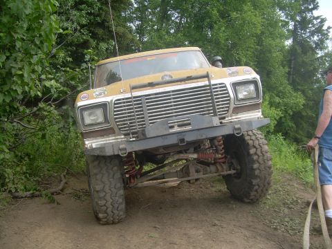 1978 Ford Bronco - Modified 1978 Ford Bronco navigating an off-road trail with lifted suspension.