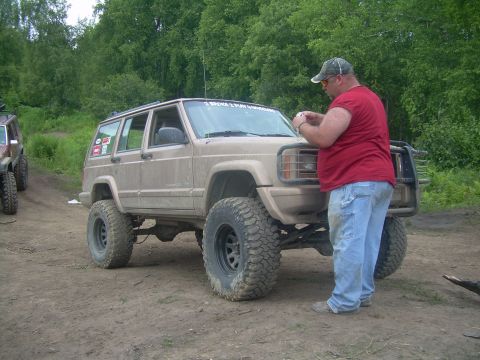 1978 Ford Bronco - Modified Jeep Cherokee XJ with off-road tires, parked outdoors with another vehicle nearby.