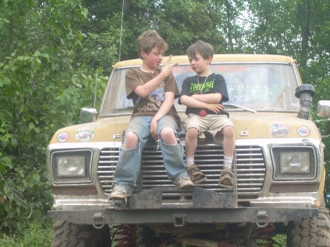1978 Ford Bronco - Two boys sit atop the hood of a lifted yellow 1978 Ford Bronco, enjoying a sunny day.