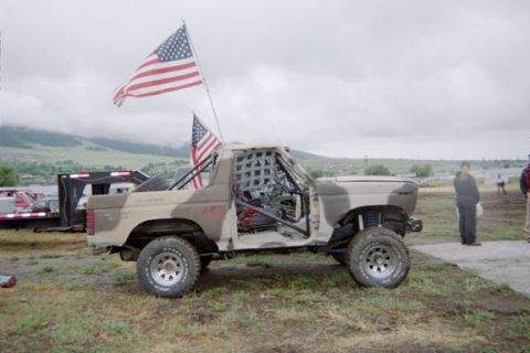 1985 Ford Bronco - This modified Ford Bronco, likely from the 1980s, is equipped for off-road racing with a roll cage and removed doors.