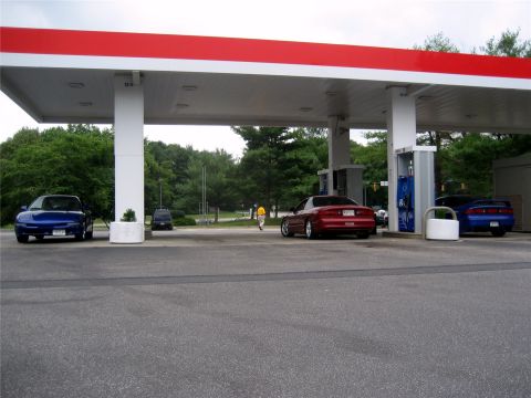 1993 Ford Probe - Three vehicles, including two 1993 Ford Probes, are visible at a gas station.