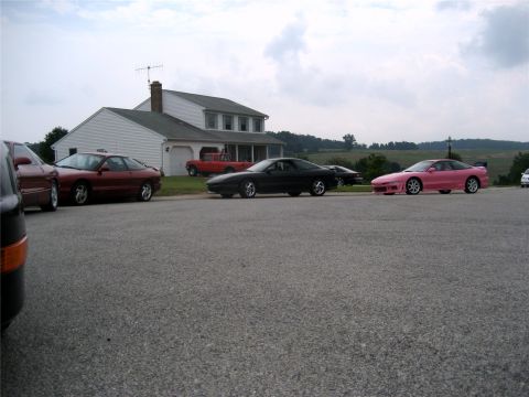 1993 Ford Probe - A trio of Ford Probes, including a distinctive pink example, are gathered in front of a suburban home.