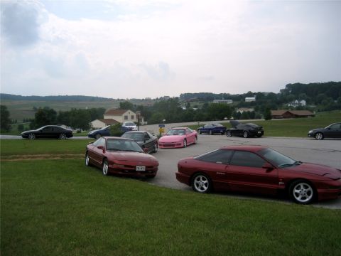 1993 Ford Probe - A maroon 1993 Ford Probe is parked on the side of a road with several other cars in the background. The car is viewed from the side at a 3/…