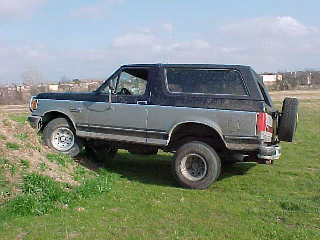 Side view of two-tone blue and silver Ford Bronco with hardtop on grass