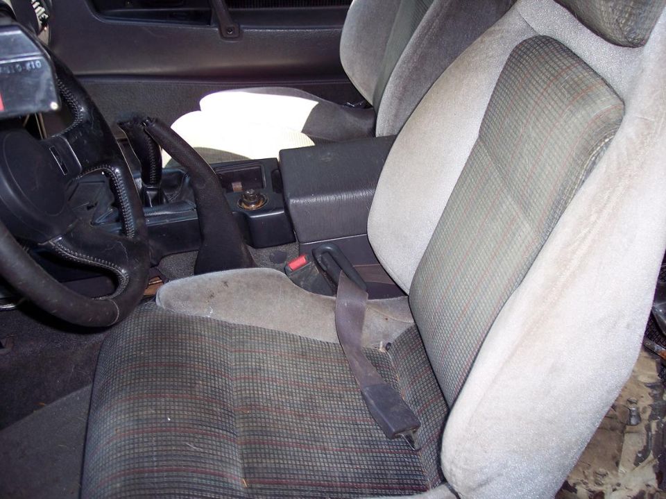 Interior of a car showing driver's seat, steering wheel, center console, and handbrake.