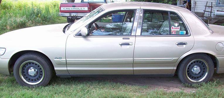 Side profile photo of a gold Mercury Grand Marquis sedan