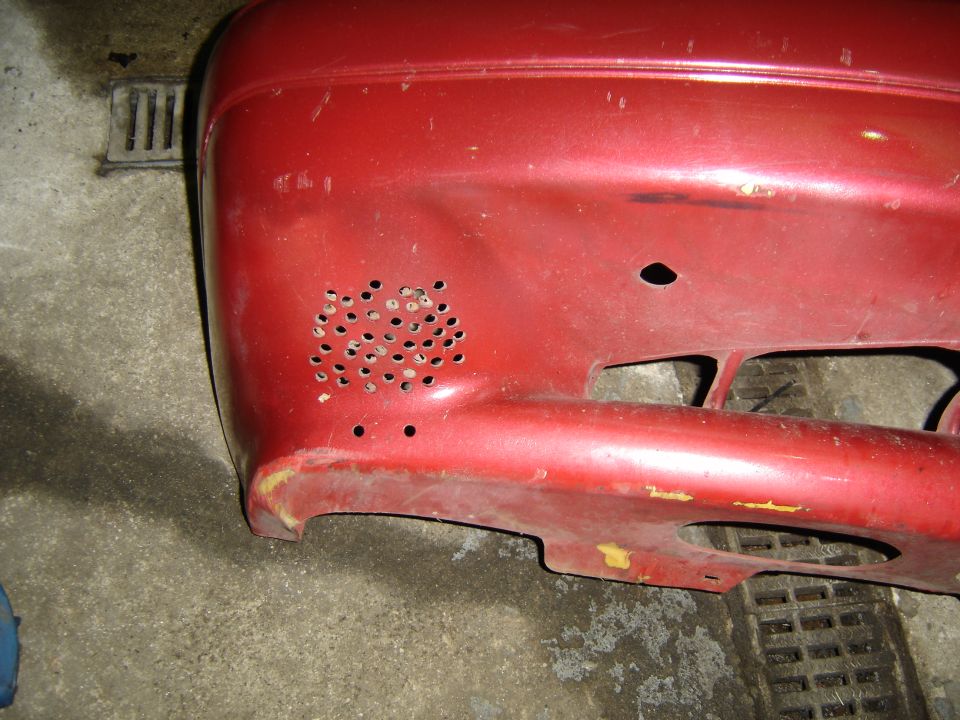 Red car bumper with drilled holes