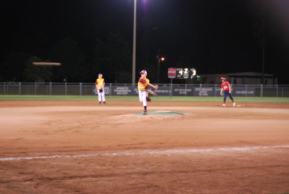 Baseball game at night with players on the field.