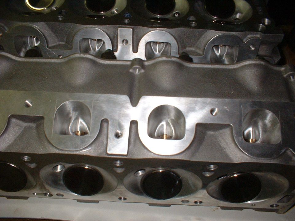 Two bare V8 cylinder heads with freshly machined and ported intake port faces
